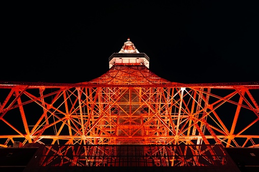 Tokyo tower at night looking up.