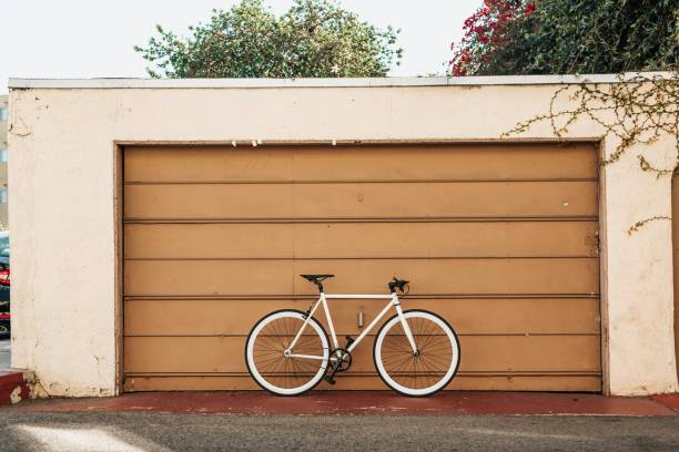 istock Single bicycle parked near a large brown garage on a sunny day 1440266797