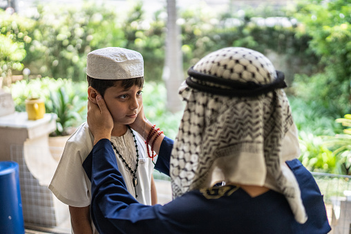 Proud young man talking to younger brother in the balcony