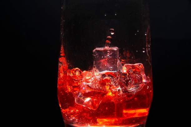 Summer creative composition made of  glass with hibiscus flower water on pastel background with sunlit and shadows. Refreshment concept. Color of the year 2023 inspired