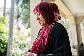 Mature islamic woman praying in the balcony at home