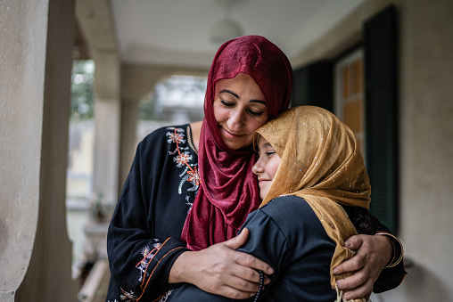 Mother and daughter embracing at home