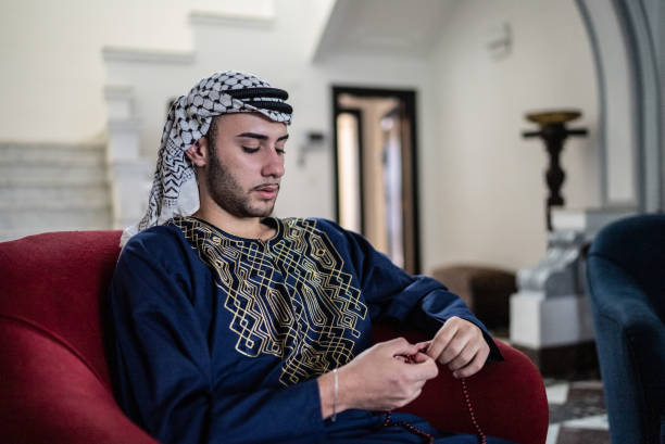 istock Young man praying with prayer beads at home 1440268681