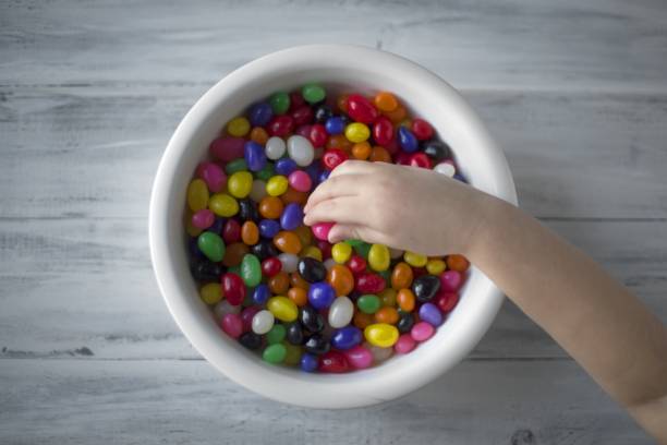 istock A child's hand picking up candy from a white plate 1440269799