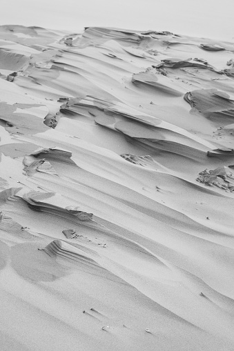 A beautiful black and white shot of sand on a beach
