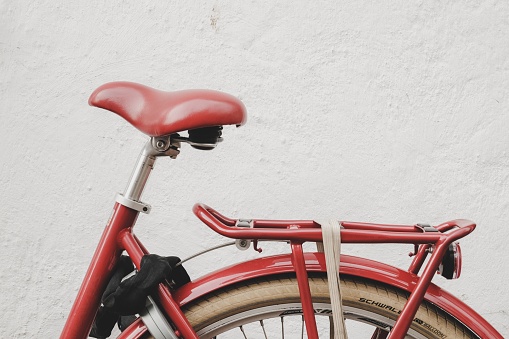 Red old bicycle saddle with white background