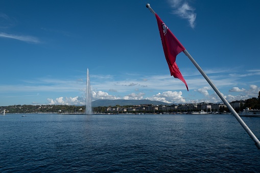 Swiss flag waving against the lake Geneva