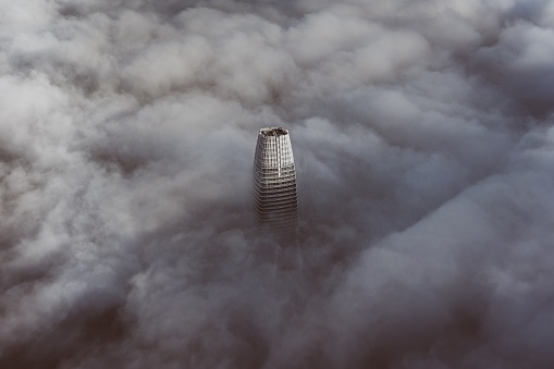 The top of the tallest building in San Francisco enveloped with clouds.