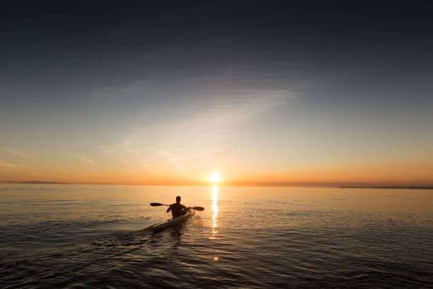 istock A man in a rowboat going towards the sunrise 1440271126