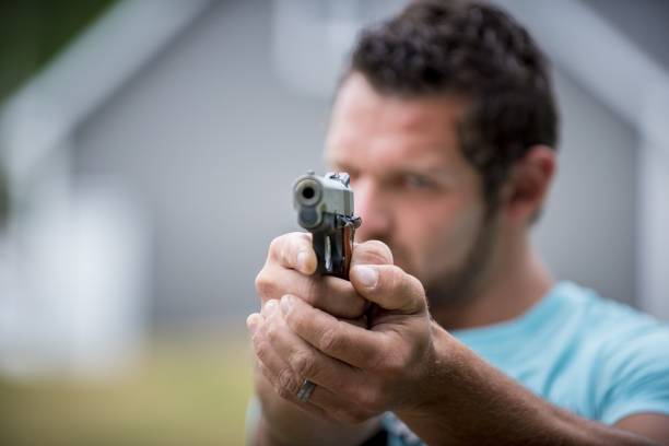 istock Male holding a pistol up towards the camera 1440273237