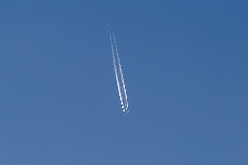 A low angle shot of an engine trail in the clear sky - great for a cool background