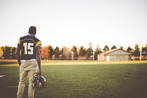 An American football player standing in the field getting ready for the match