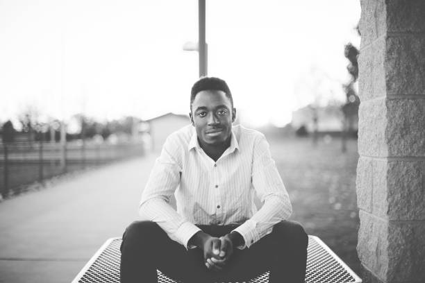 istock Grayscale shot of a male sitting while looking at the camera 1440273591