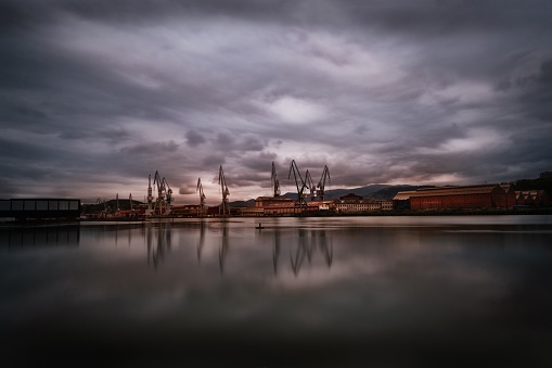 Ciudad portuaria industrial de Bilbao reflejada en el lago bajo las nubes de tormenta en Vizcaya, España photo