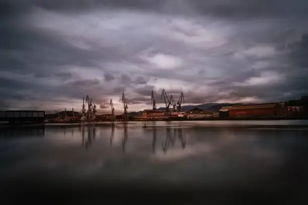 The Bilbao industrial port city reflected in the lake under the storm clouds in Vizcaya, Spain