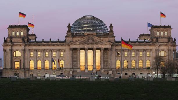 bellissimo edificio del bundestag con le bandiere tedesche contro il cielo del tramonto a berlino, germania - central berlin foto e immagini stock