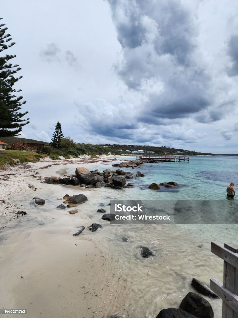 Vertical shot of a sandy beach with big stones and a person standing in the water A vertical shot of a sandy beach with big stones and a person standing in the water Beach Stock Photo Vertical shot of a sandy beach with big stones and a person standing in the water A vertical shot of a sandy beach with big stones and a person standing in the water Beach Stock Photo