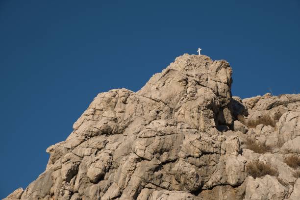 istock Cross on the rock at a far range in Symi island, Greece 1440274888