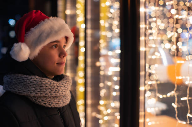istock Boy in Santas hat looking in shop window 1440275056