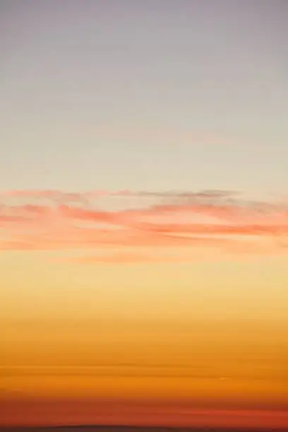 A vertical shot of the golden sunset sky over the Pacific Ocean - perfect for a background wallpaper