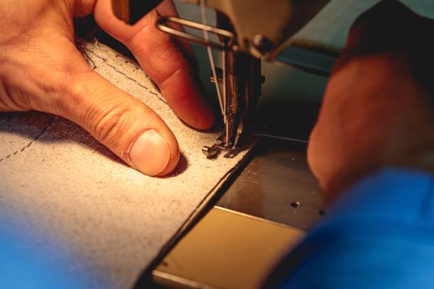 maroquinier professionnel confectionnant un vêtement en cuir avec une machine à coudre - belt leather fashion women photos et images de collection