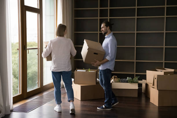 istock Spouses carrying cardboard boxes into living room on relocation day 1440276572