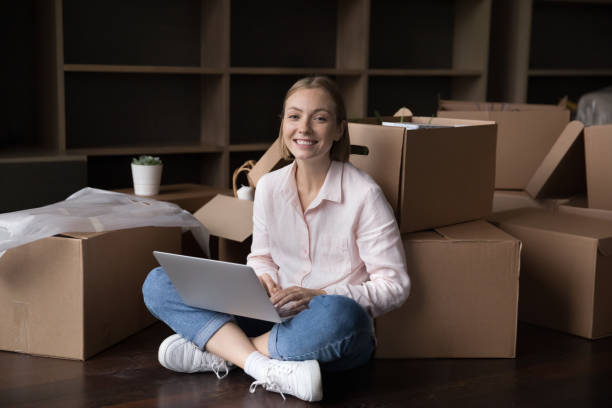 istock Woman sit on floor with laptop near boxes on moving 1440276579