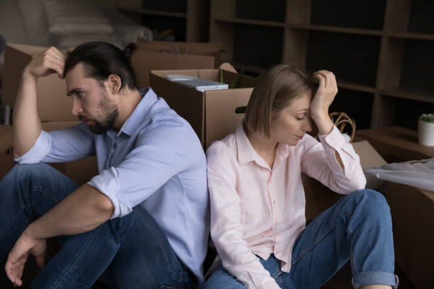 istock Unhappy tired couple sit on floor near boxes with stuff 1440276607
