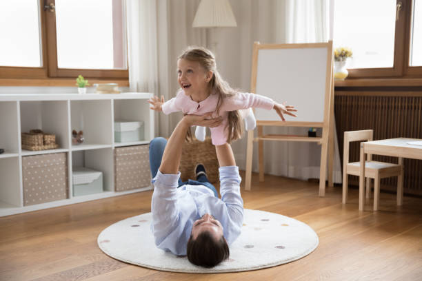 istock Daughter spread arms imagining flying in air play with dad 1440276776