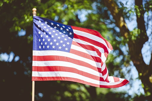 Closeup shot of the united states flag on a pole with a blurred background
