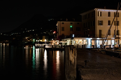 The port of Gargnano, Italy at night with bright lights shot from the pier side