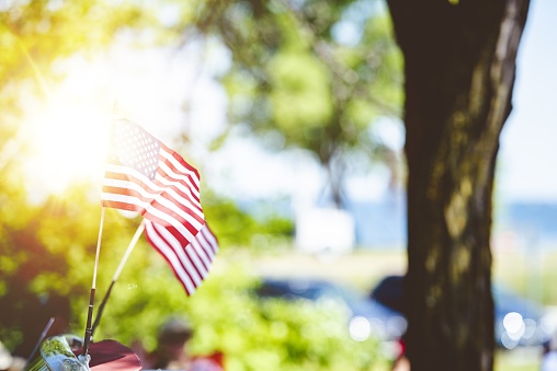 Closeup shot of small untied statues flag attached to a car with a blurred background