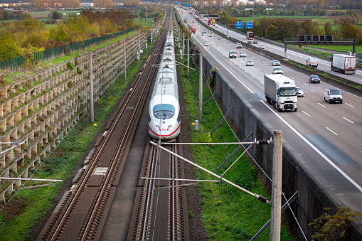 Bonvilston, Vale of Glamorgan, Wales - September 2022: Aerial view of a commuter train passing a level crossing on the outskirts of Cardiff.