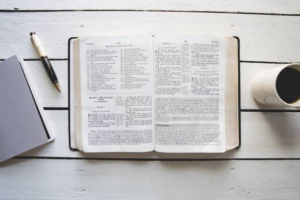 istock Overhead shot of an open bible in between a coffee and a notepad with a pen 1440282766