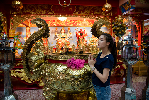 Chinese woman homage to Chinese god at shrine. Concept to celebrate Chinese New Year.
