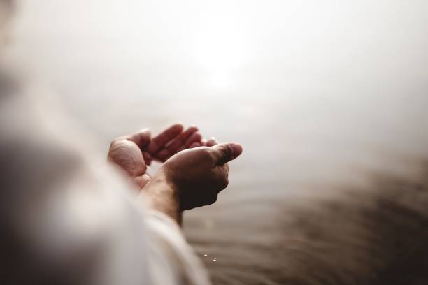 High angle shot of Jesus Christ holding water with his palms A high angle shot of Jesus Christ holding water with his palms baptism stock pictures, royalty-free photos & images