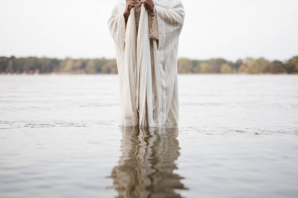 istock Person wearing a biblical robe standing in the water with a blurred background 1440283677