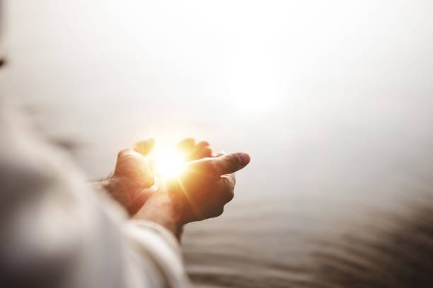 tiro bonito de jesus cristo que prende a esperança e a luz em suas palmas com um fundo borrado - penance - fotografias e filmes do acervo