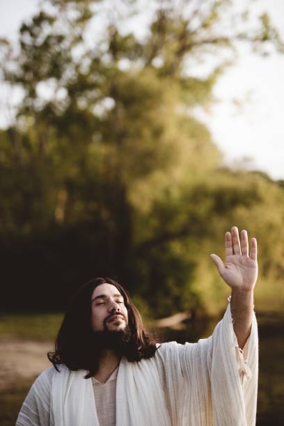 istock Jesus Christ whit his hand up towards the sky while his eyes are closed 1440284592