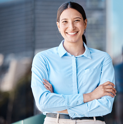 Business woman standing at the modern office building, smiling.  Horizontal photo.