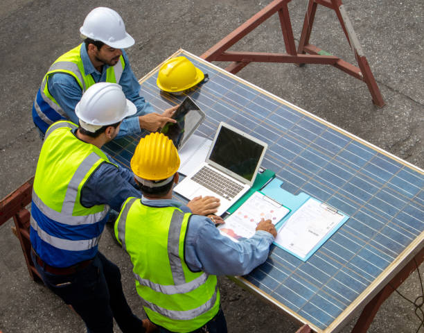 istock Brainstorming communications of technician professional team in safety helmets and uniforms with solar photovoltaic panel 1440285606