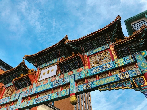 A beautiful low angle shot of teal and red temple gate in Gallery Place Chinatown under the breathtaking sky