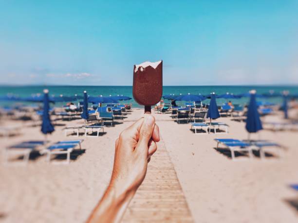 istock A person holding a bitten chocolate ice-cream on the beach with a blurred background 1440286797