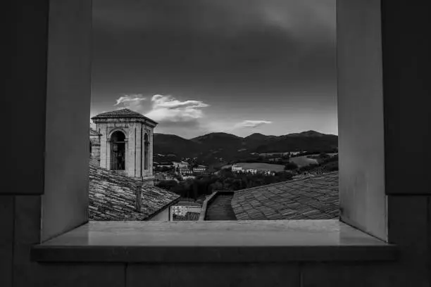Photo of Greyscale shot of the cathedral of Cascia. Outdoor balconies in the square of Cascia, Italy