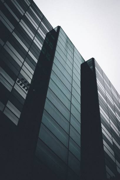 istock Vertical low angle shot of a black building with mirror windows under the clear sky 1440288251