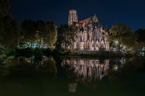 A nighttime shot of the protestant church Johanneskirche near a lake in Stuttgart, Germany