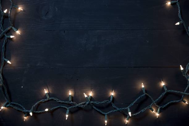 istock Overhead shot of tree lights over a black wooden surface 1440288752