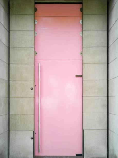 istock Vertical shot of a pink door between two light stone walls 1440289414