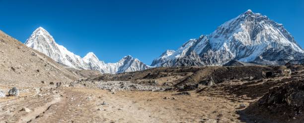 istock Panoramic shot of a beautiful valley surrounded by mountains covered in snow. 1440289799
