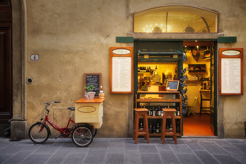 Florence, Italy – June 26, 2014: Welcoming storefront on a beautiful cobblestone street in Florence Italy